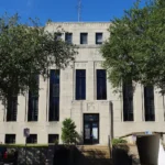 Fachada clara do tribunal do condado de Van Zandt, em Canton, no Texas, entre árvores, com uma picape estacionada em frente (foto de arquivo, 2017)