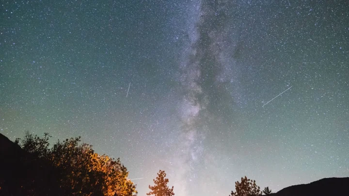 Meteoros cruzam o céu durante a chuva de meteoros Oriônidas de 2017, com a Via Láctea visível no alto.