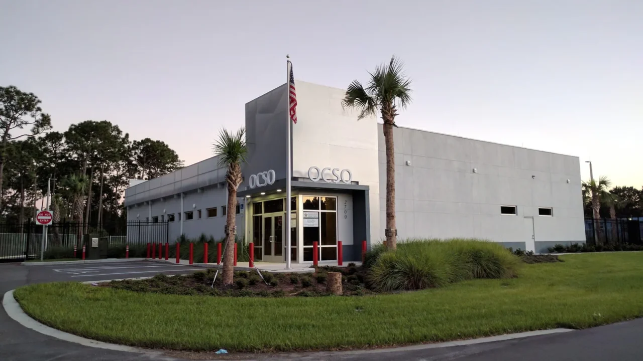 Prédio do Gabinete do Xerife do Condado de Orange, com a sigla OCSO na fachada, palmeiras e uma bandeira dos EUA no mastro, perto de Disney Springs, na região de Orlando, em foto de arquivo de 2016, sem relação com a cerimônia