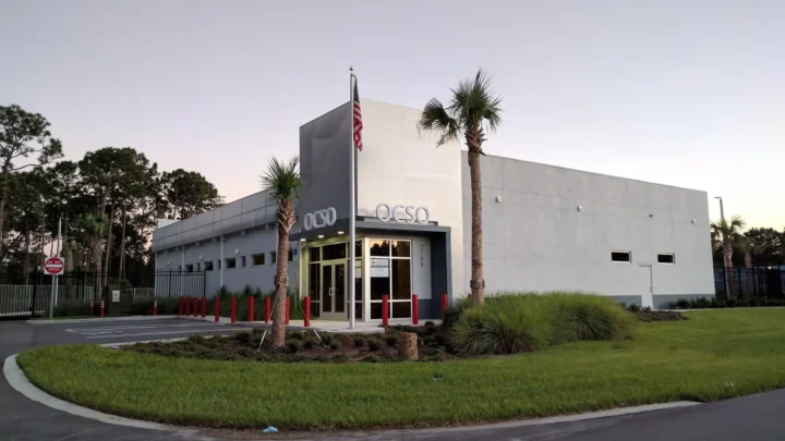 Prédio do Gabinete do Xerife do Condado de Orange, com a sigla OCSO na fachada, palmeiras e uma bandeira dos EUA no mastro, perto de Disney Springs, na região de Orlando, em foto de arquivo de 2016, sem relação com a cerimônia