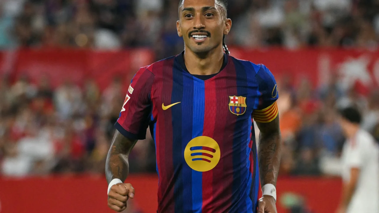 Jogador do Barcelona com a braçadeira de capitão corre em campo durante partida em estádio com torcida ao fundo