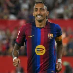 Jogador do Barcelona com a braçadeira de capitão corre em campo durante partida em estádio com torcida ao fundo