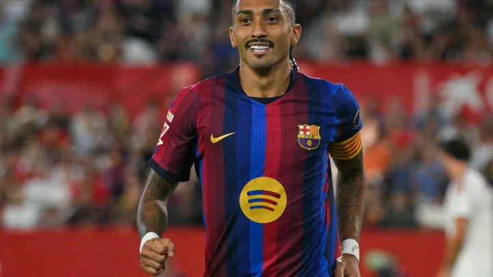 Jogador do Barcelona com a braçadeira de capitão corre em campo durante partida em estádio com torcida ao fundo