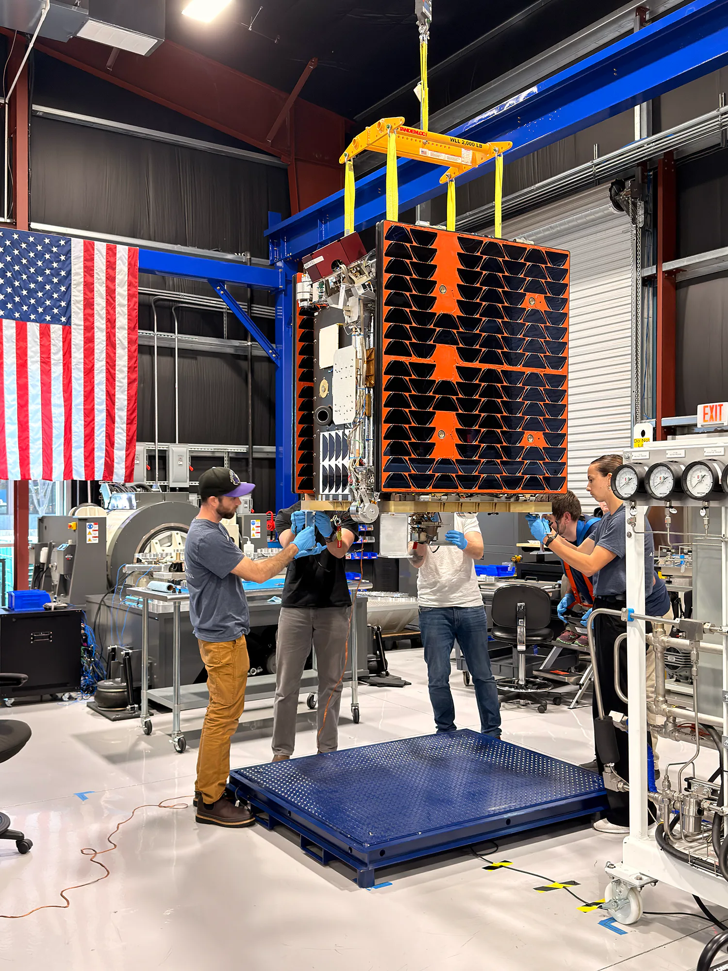 Técnicos preparam a espaçonave Otter para a missão SSPICY da NASA nas instalações da Starfish Space em Seattle. A espaçonave, que tem aproximadamente o tamanho de uma máquina de lavar roupa, navegará de forma autônoma até objetos espaciais inoperantes de origem norte-americana para inspecioná-los, testando tecnologias para um dia tornar possível o reparo no espaço.