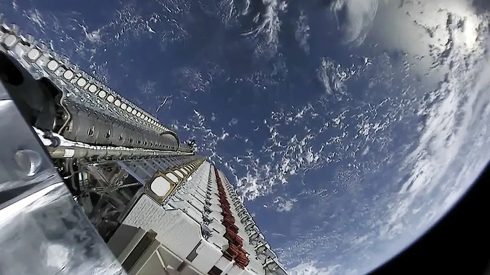 Pilha de satélites da Starlink no topo de um foguete Falcon 9, com a Terra ao fundo, pouco antes de serem soltos em órbita, em maio de 2019 (imagem de arquivo)