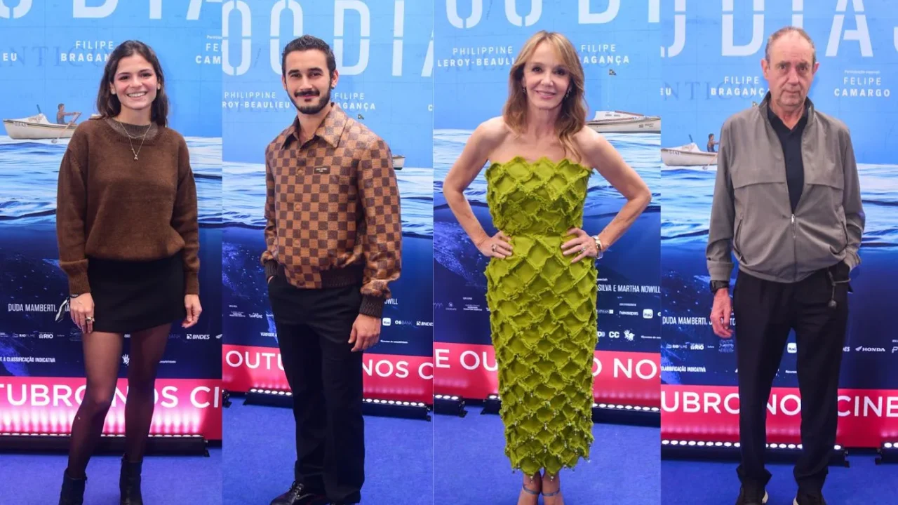 Quatro convidados posam em tapete azul com cartaz do filme "100 Dias", da esquerda para a direita: uma mulher de suéter marrom e minissaia preta, um homem de camisa xadrez marrom, uma mulher de vestido verde texturizado e um homem de jaqueta cinza