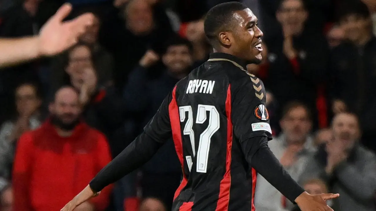 Jogador de camisa preta com listras vermelhas, de número 37 e nome "Ryan" nas costas, comemora com os braços abertos diante da torcida